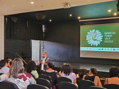 audiodescrição: Juiz Josmar de Oliveira falando para o auditório da escola.